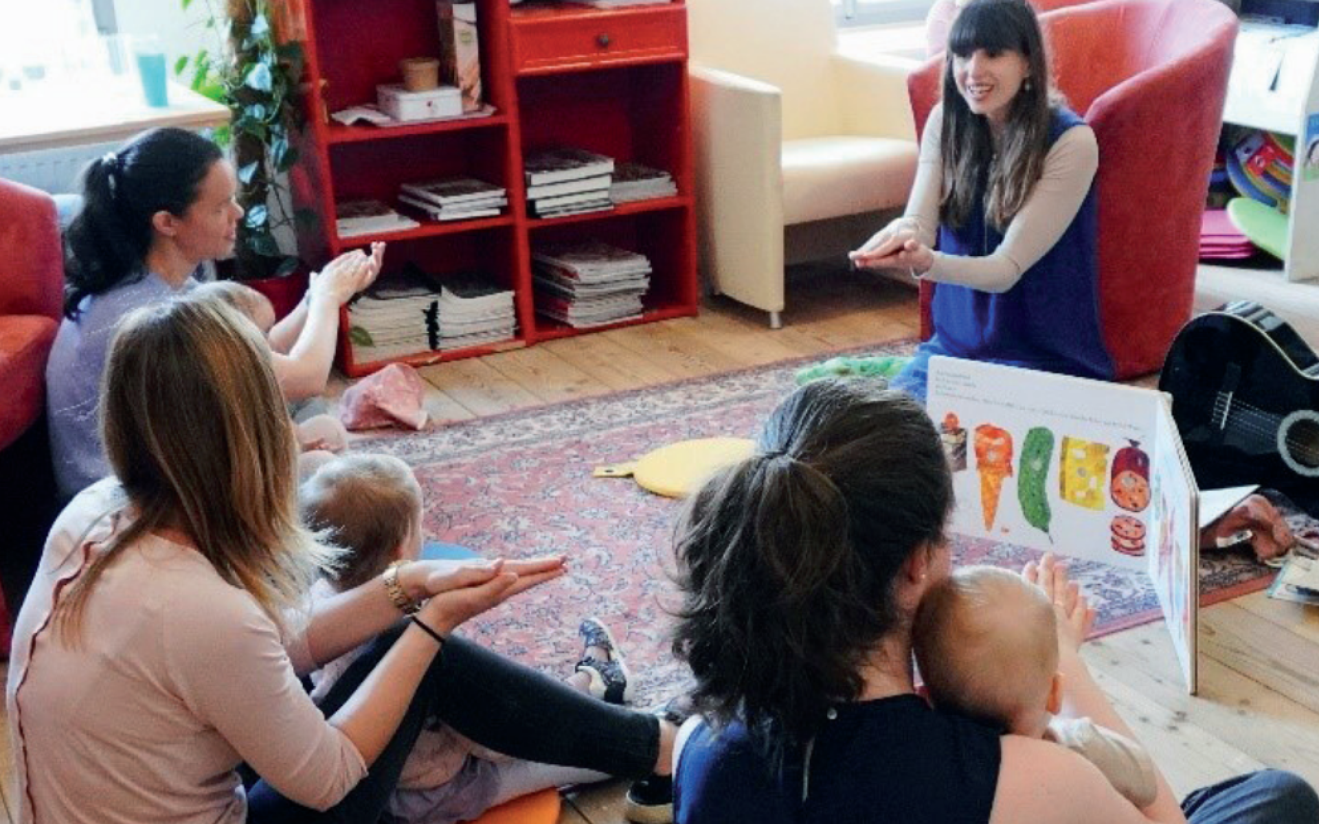 Frauen mit Kleinkindern von hinten und vorne eine Frau, die Fingerspiele vorzeigt
